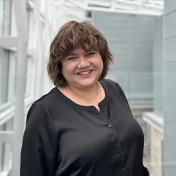 En kvinne som smiler til kameraet