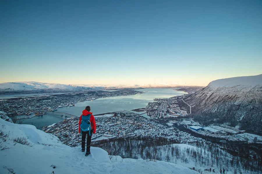 Person i fjellet ser ut over Tromsø