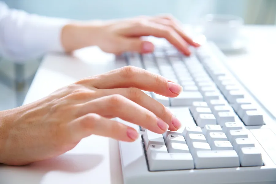 Nærbilde av hender som skriver på et tastatur
