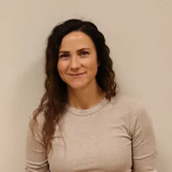 En kvinne som smiler til kameraet