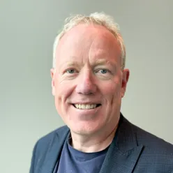 En mann som smiler til kameraet