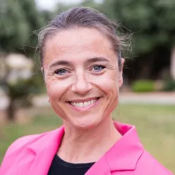 En kvinne som smiler til kameraet